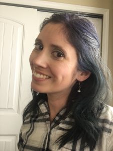 smiling Jelena with long, curly blue and green hair
